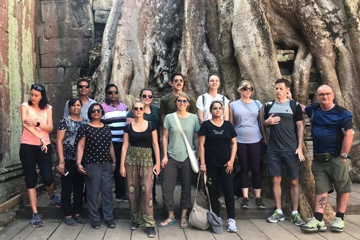 un grupo de personas de pie frente a un árbol