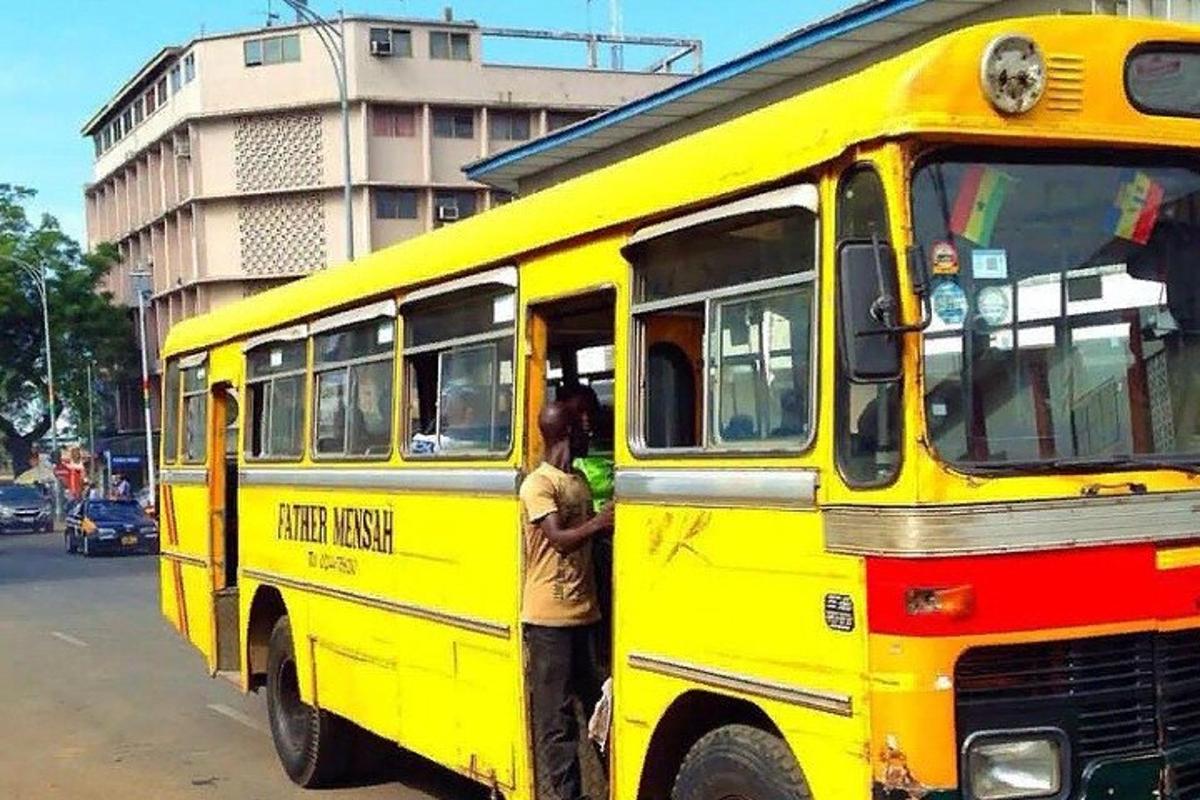 Muž stojí vedle žlutého autobusu