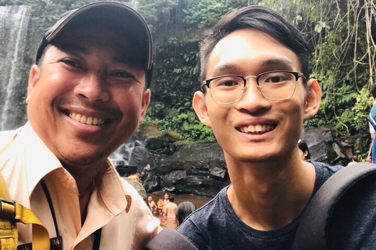 due uomini sorridono davanti a una cascata