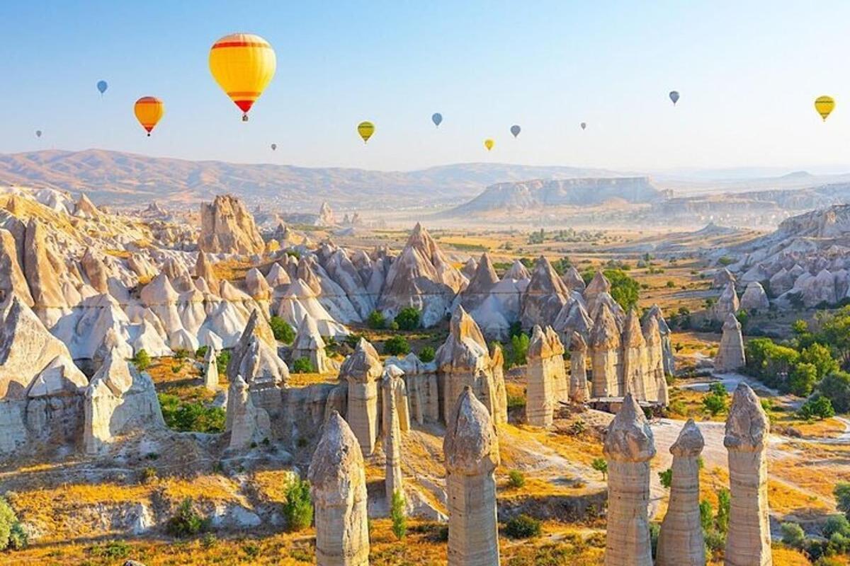 Μια ομάδα αερόστατων θερμού αέρα που πετούν πάνω από την έρημο της Καππαδοκίας