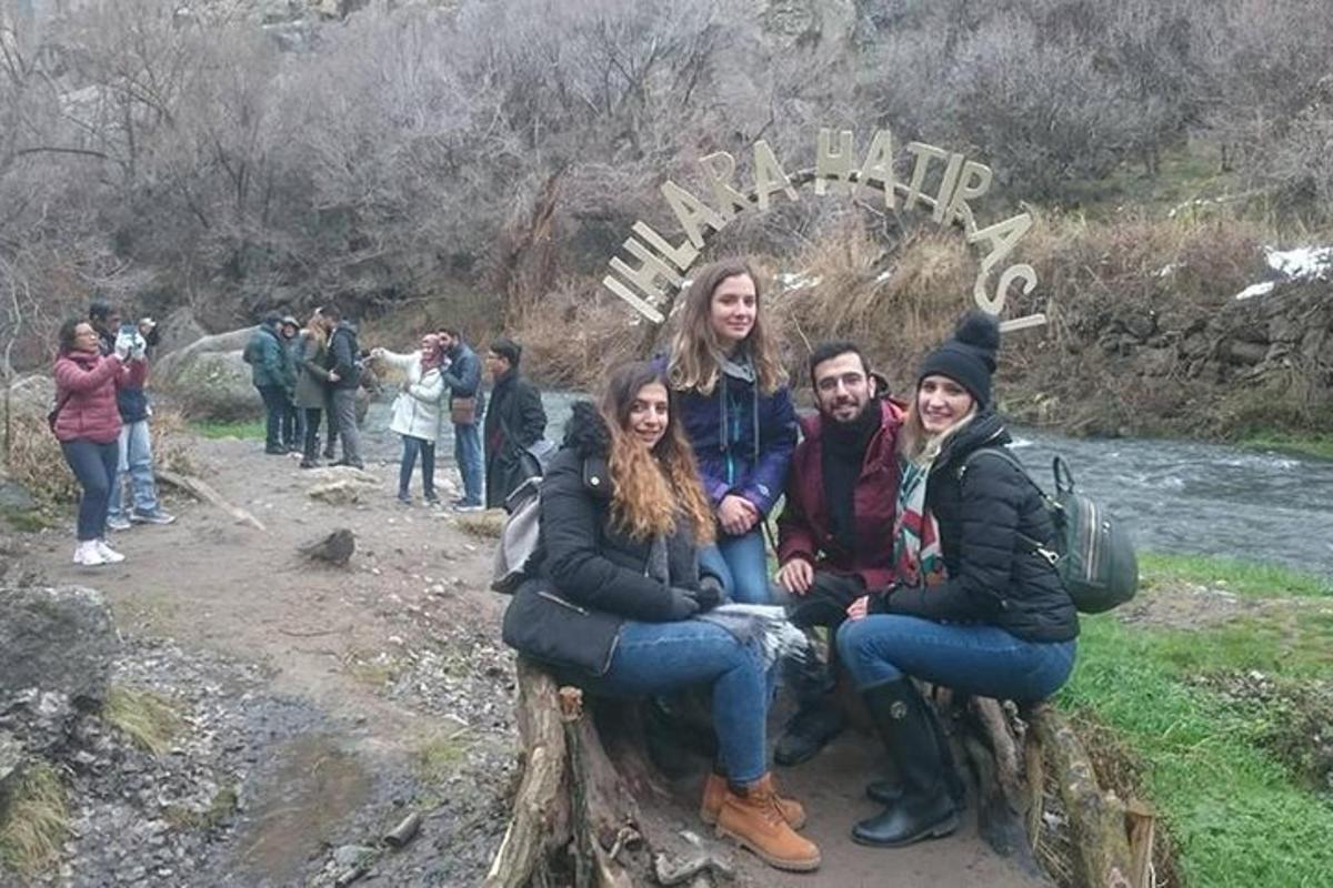 группа людей сидит на скамейке перед знаком
