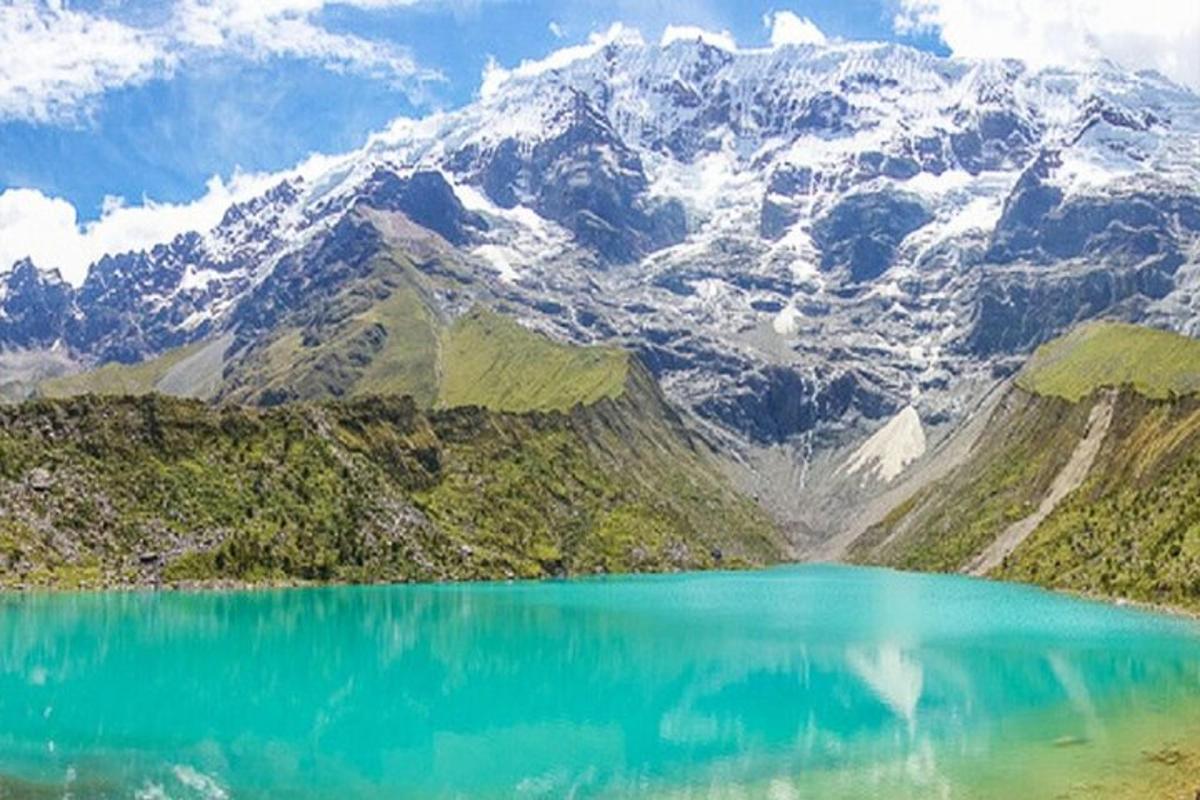 isang lawa ng bundok na may mga bundok na natatakpan ng niyebe sa background
