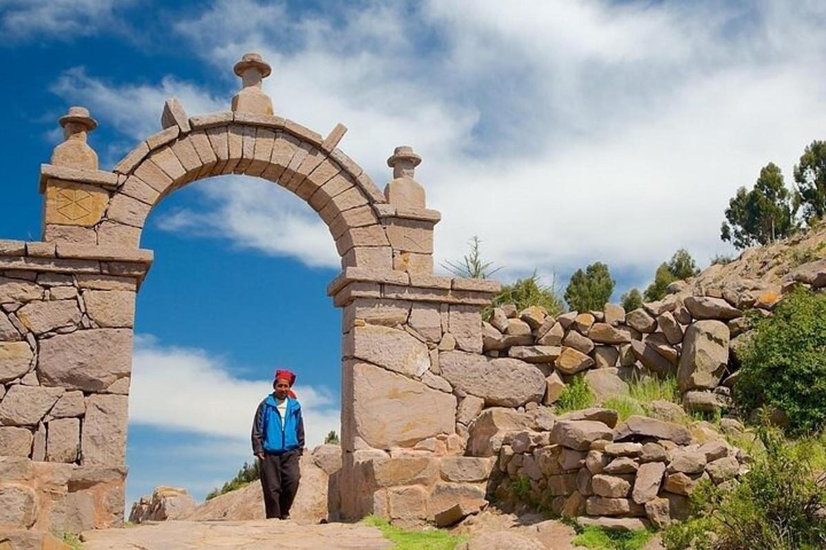 un uomo che cammina attraverso un arco in un muro di pietra