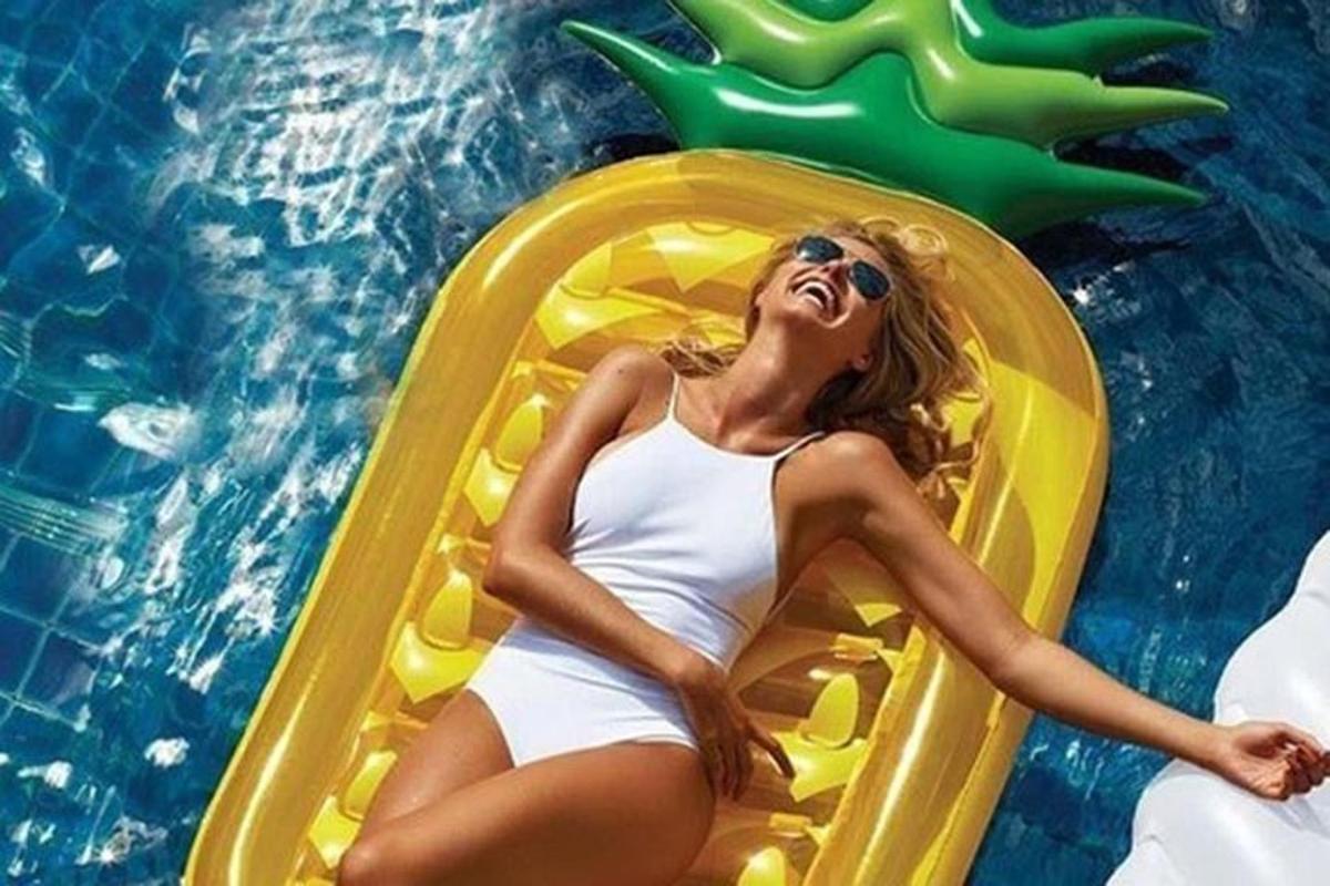 Una mujer está tumbada en una balsa en una piscina.