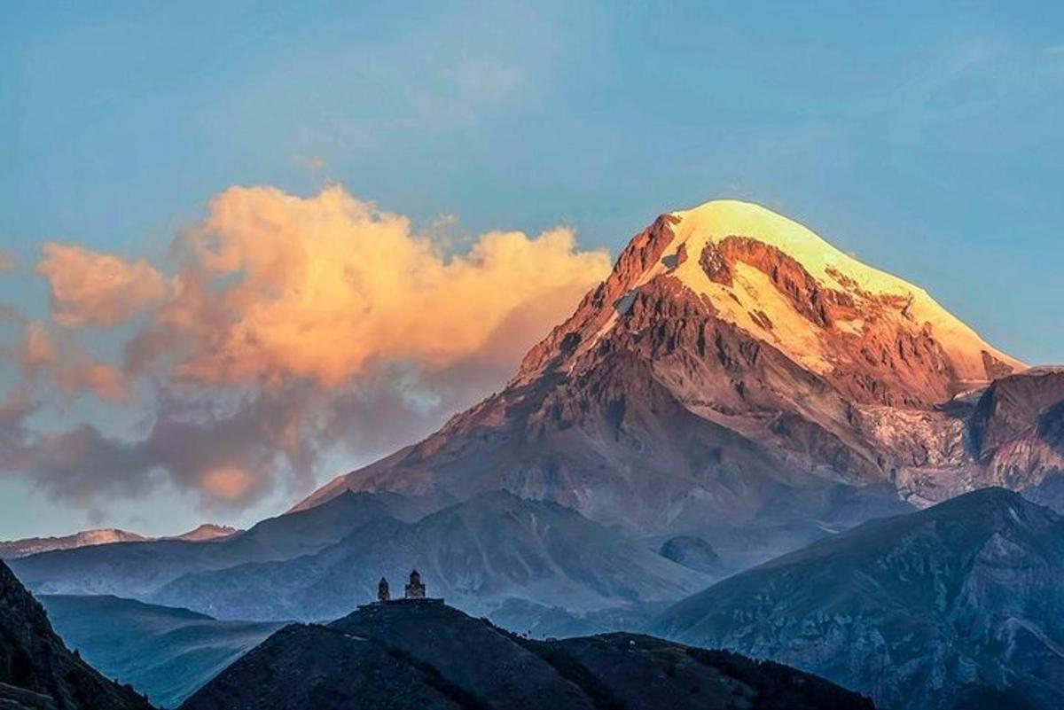 two people standing on top of a mountain
