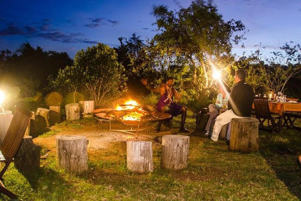 un gruppo di persone sedute attorno a un fuoco da campo