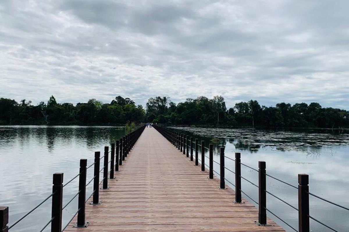 un ponte di legno sopra un grande specchio d'acqua