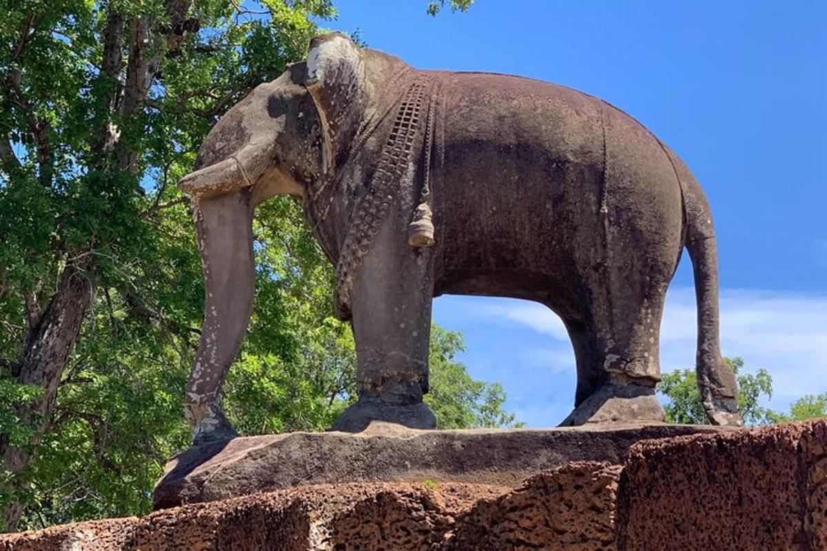 en statue af en elefant, der står oven på en mur