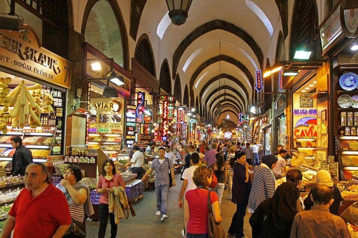 uma multidão de pessoas caminhando por um mercado com lojas