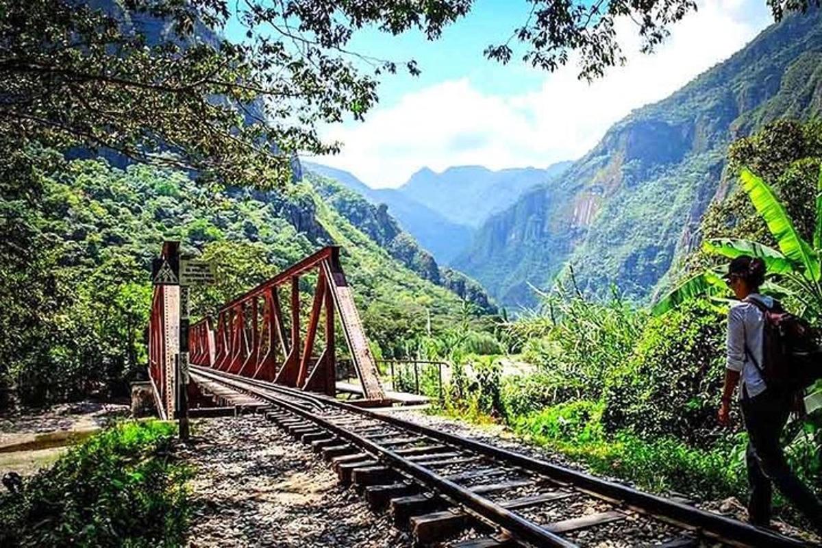 un uomo che cammina su un ponte sopra una montagna