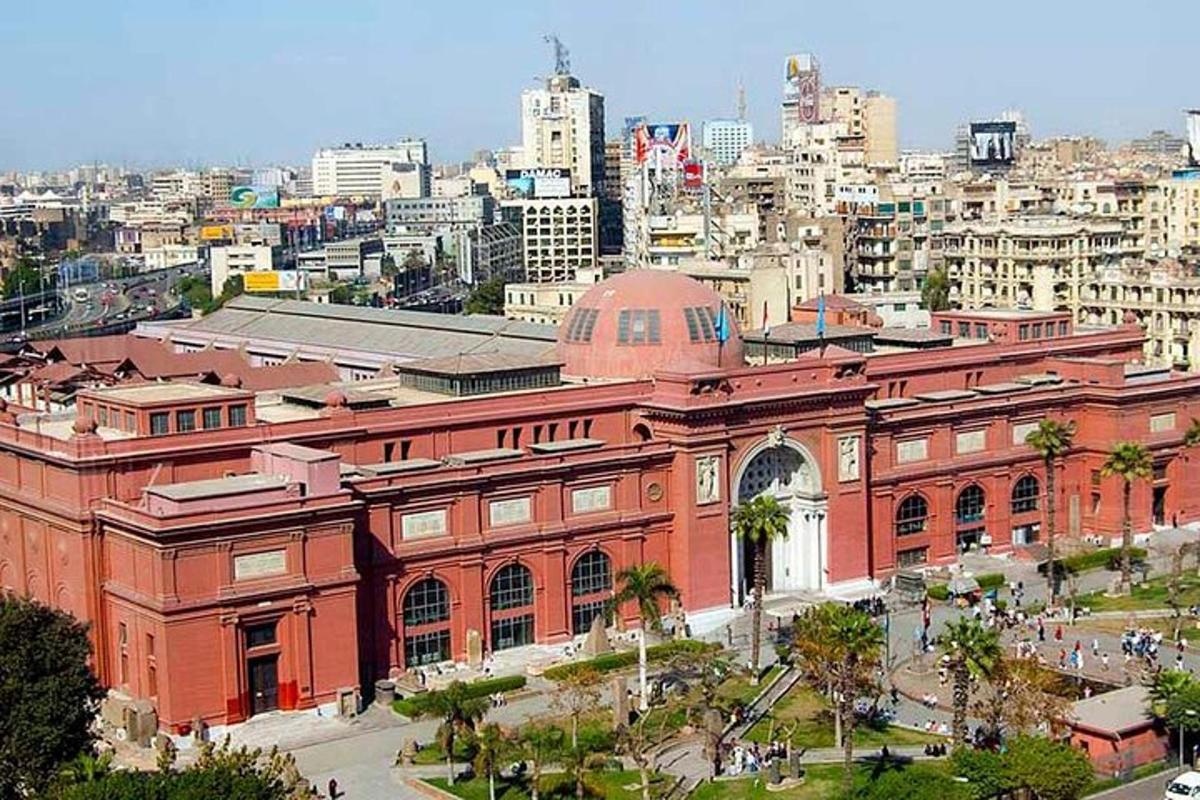 un grande edificio in mattoni rossi con una città sullo sfondo