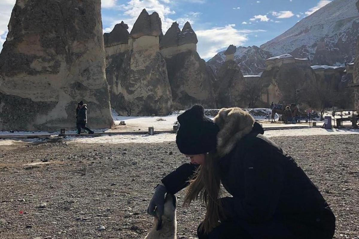 a woman kneeling on the ground with a dog