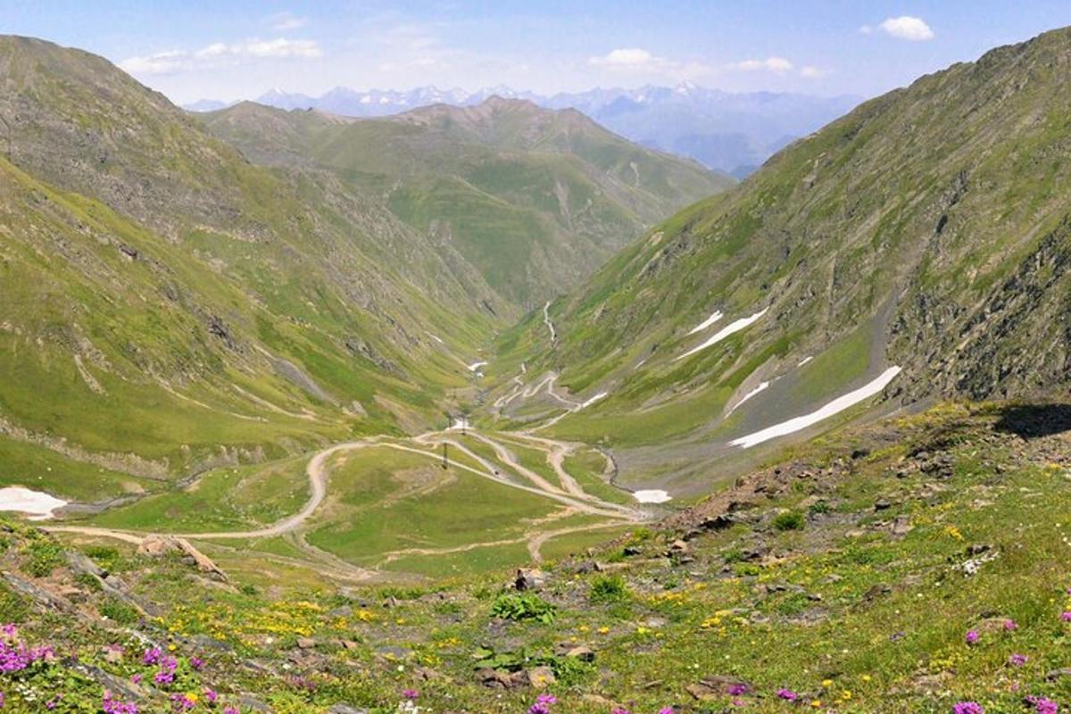 Blick auf ein Bergtal mit einer unbefestigten Straße