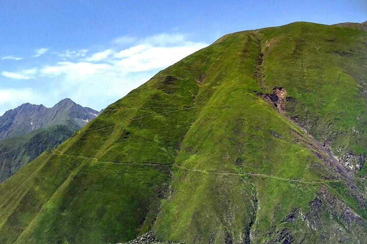 un turó cobert d'herba verda al cim d'una muntanya
