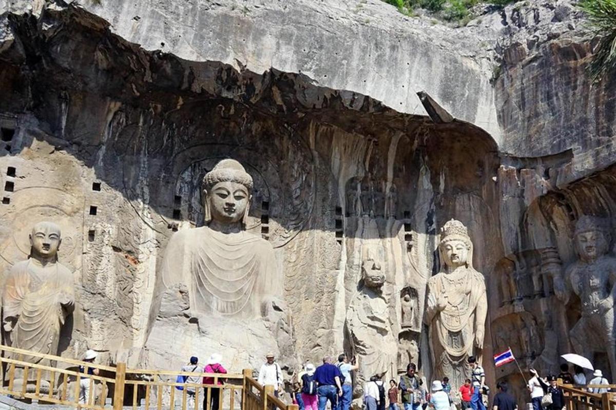 a group of people standing in front of a large statue