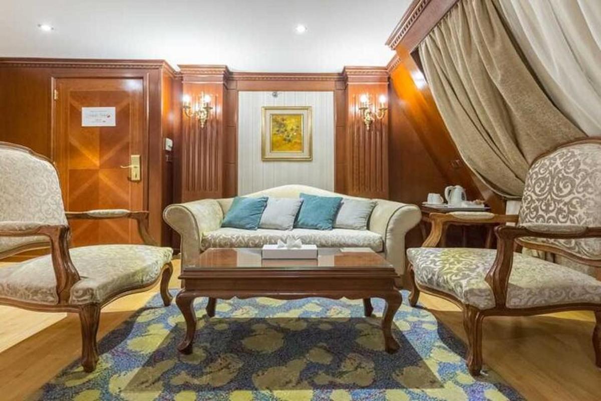 ruang tamu dengan sofa dan dua kerusi
