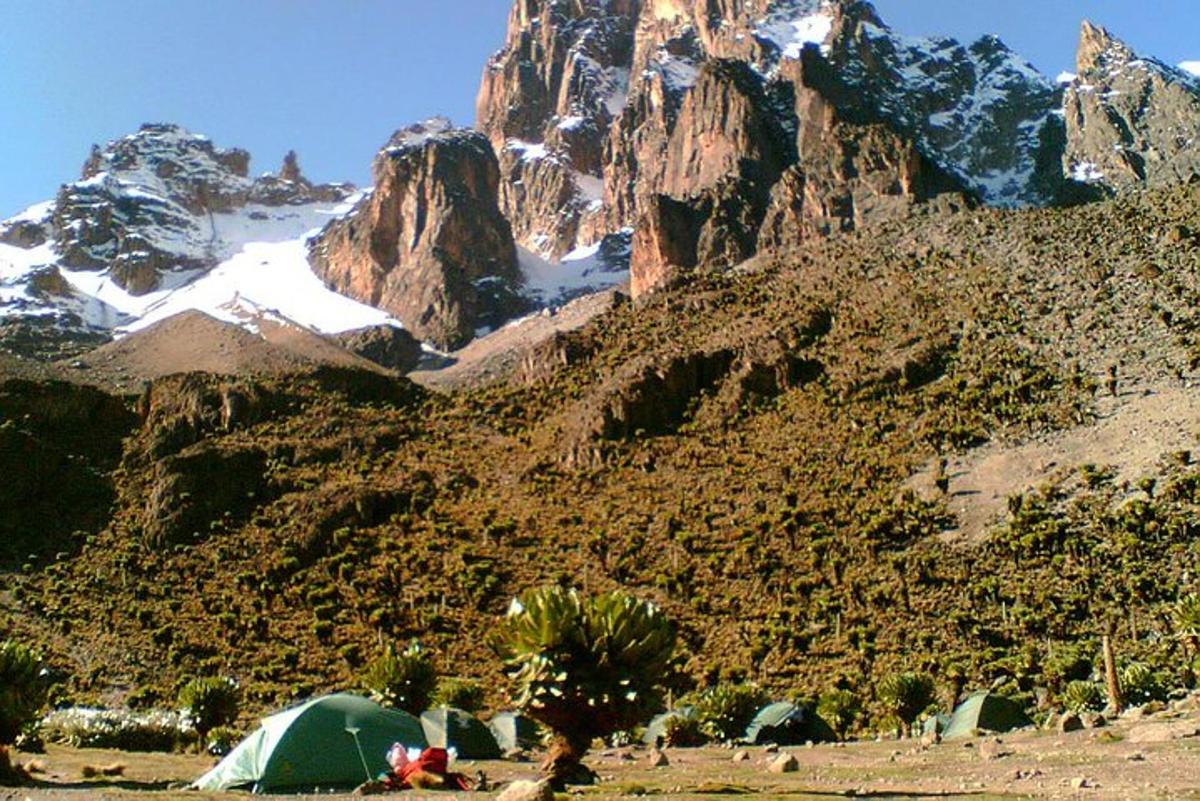 a group of tents and a mountain with snow