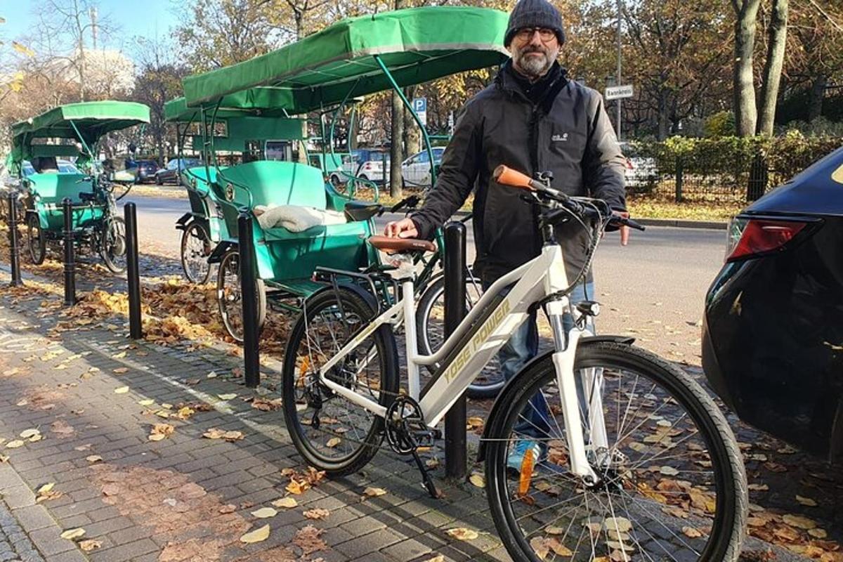 muž stojící vedle kola s vozíkem
