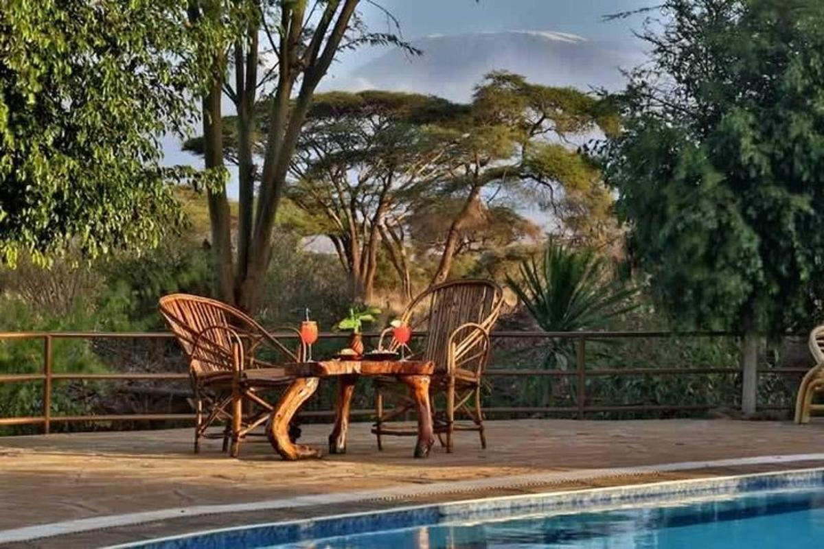 uma mesa de madeira e cadeiras ao lado de uma piscina