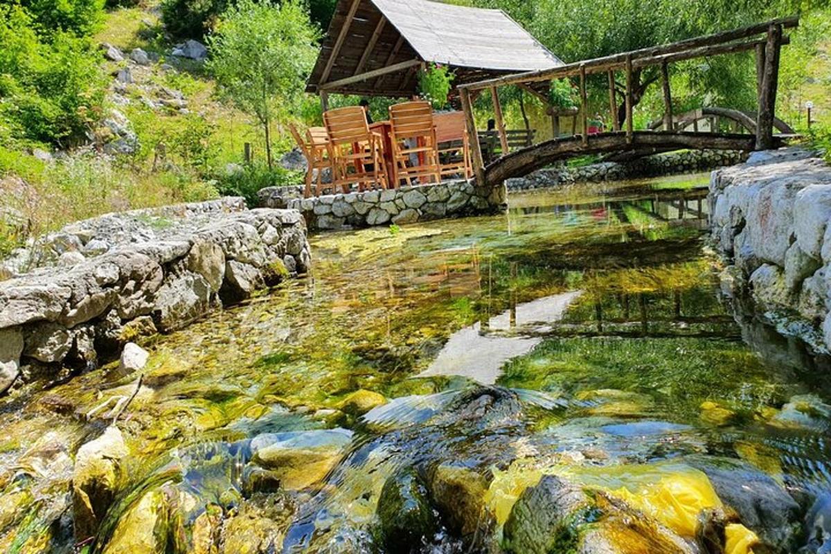 una casa amb cadires i un pont sobre un rierol