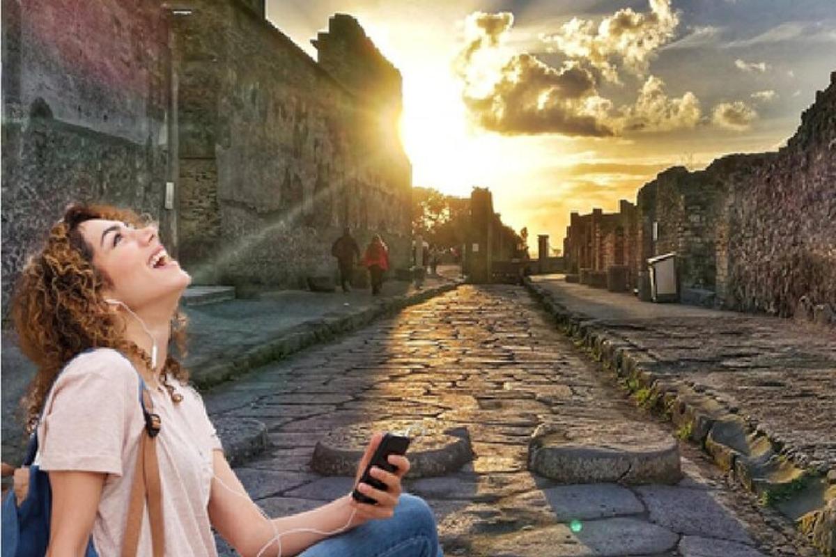 žena sedící na zemi a dívající se na mobilní telefon