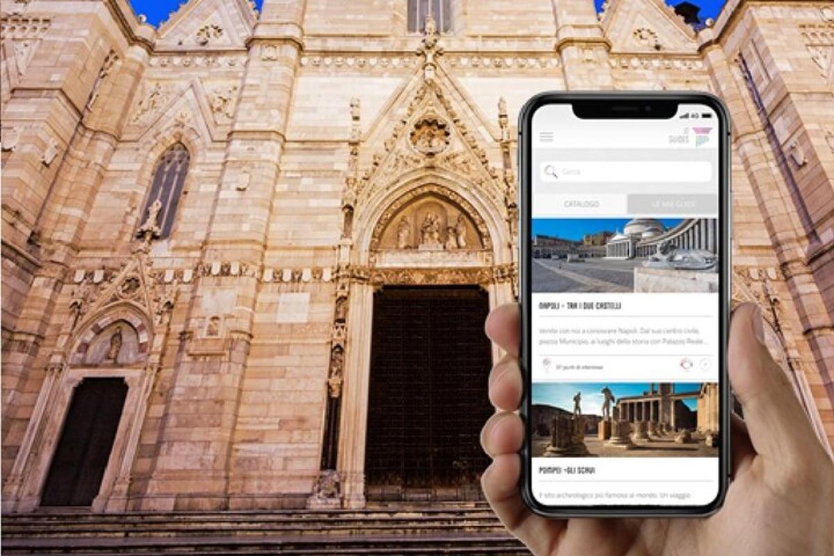 osoba držící mobilní telefon před kostelem