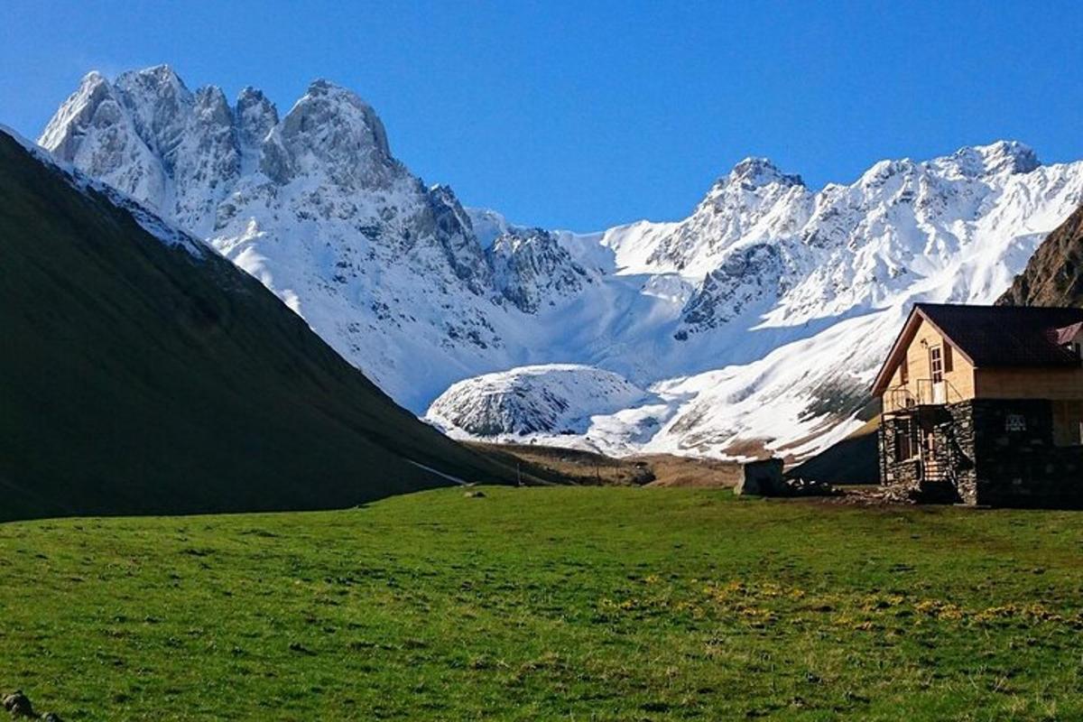 sebuah rumah di padang dengan gunung yang dilitupi salji