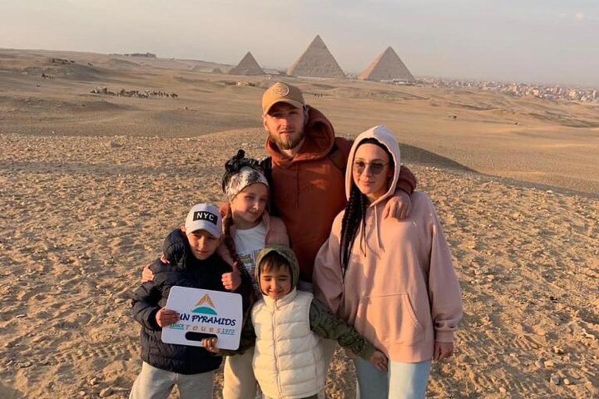 una famiglia posa per una foto davanti alle piramidi
