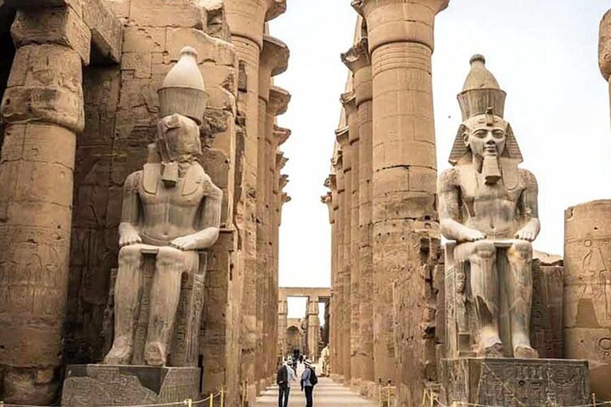 two large statues of people standing between two columns