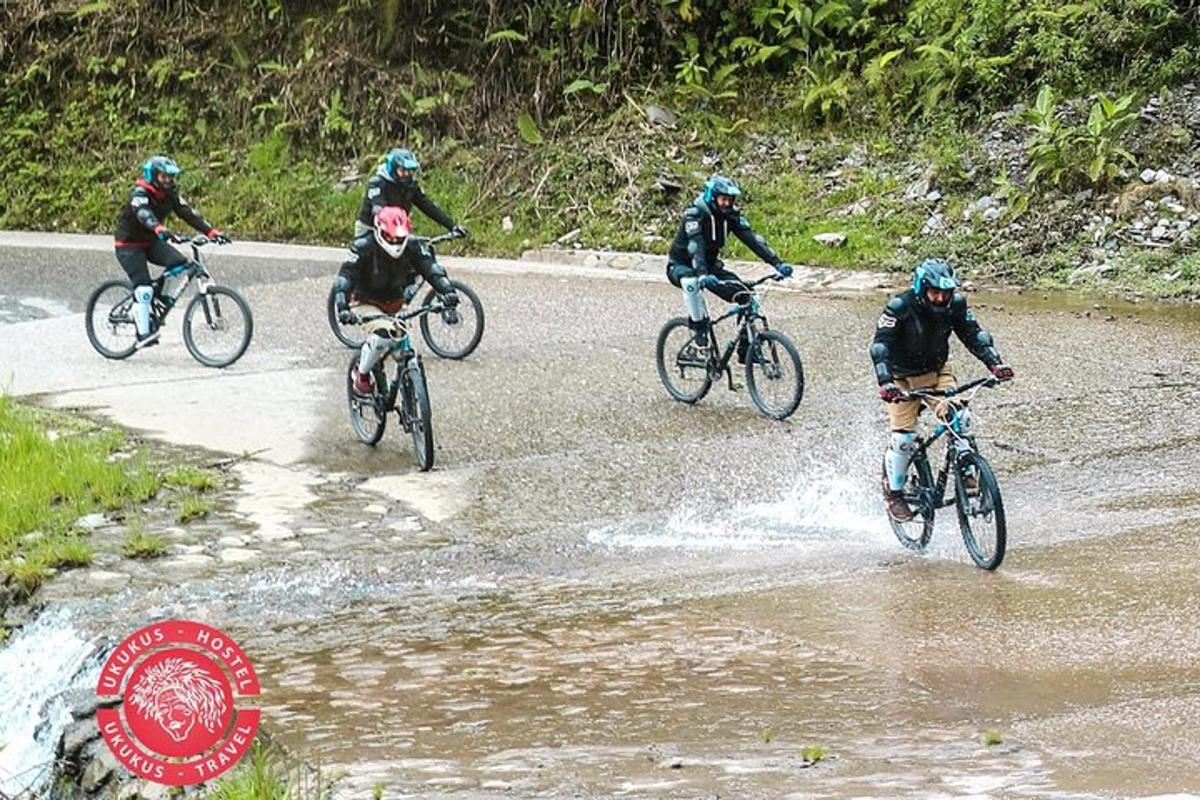 skupina lidí jedoucích na kolech přes řeku
