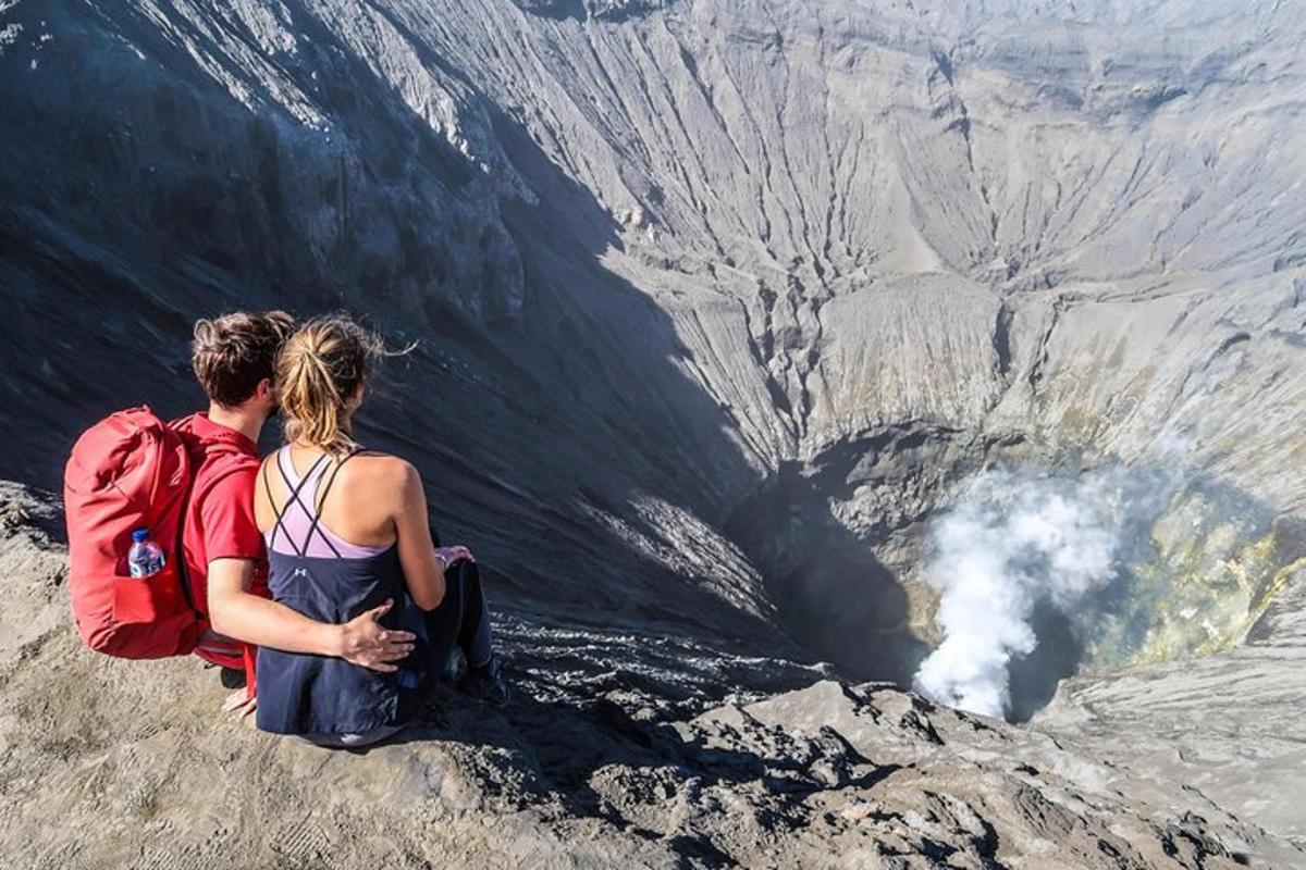 a man and a woman sitting on top of a mountain