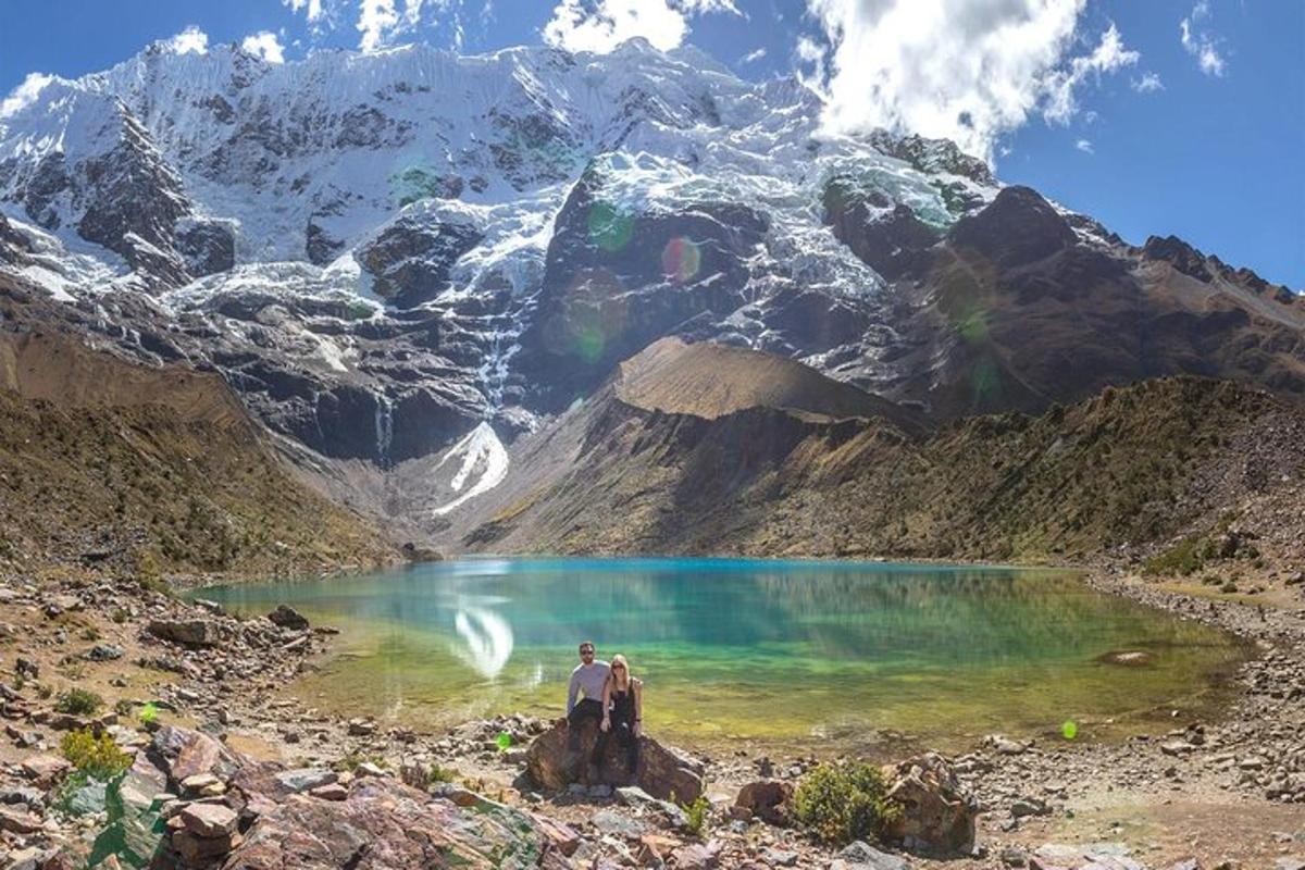 duas pessoas em pé em frente a um lago na montanha