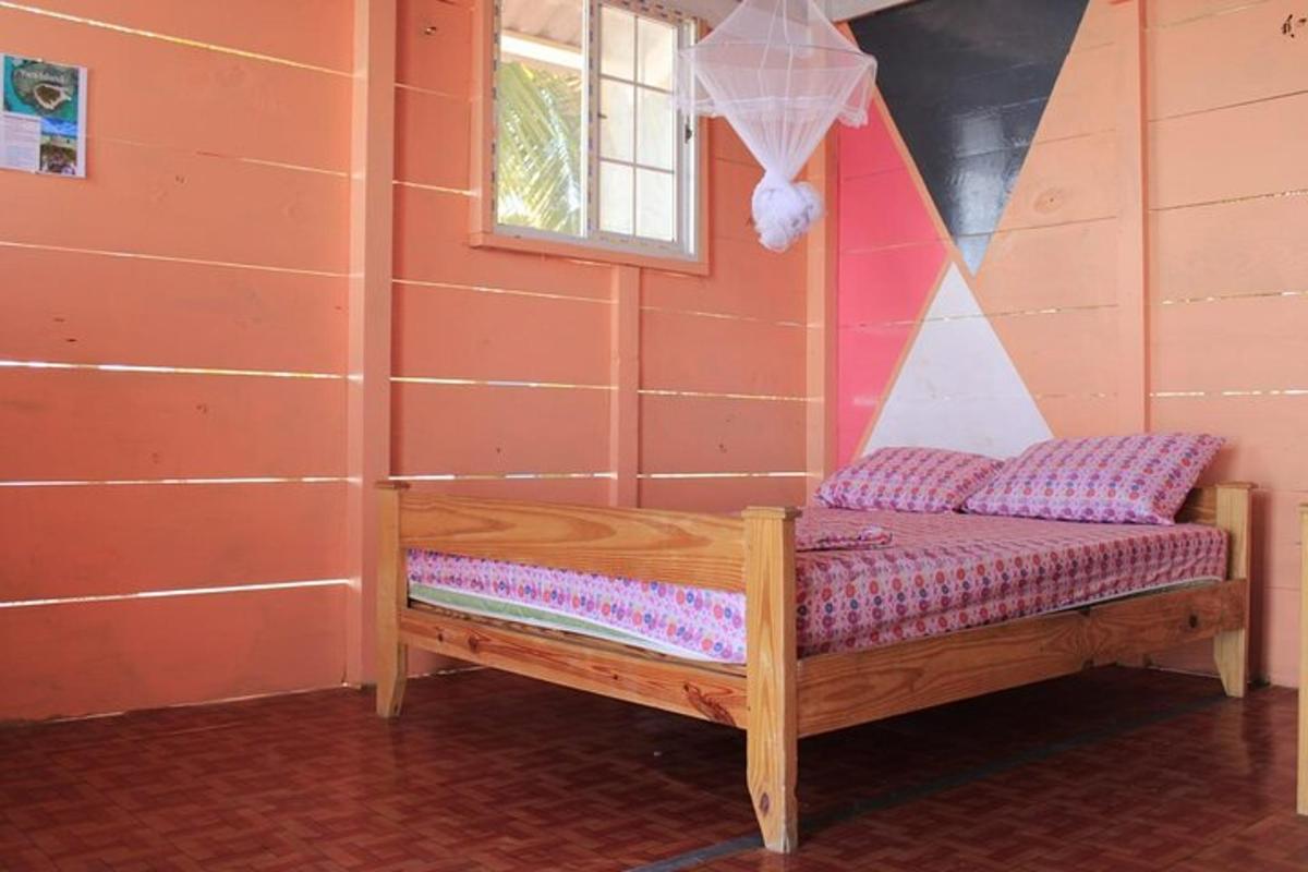 un petit llit de fusta en una habitació amb finestra