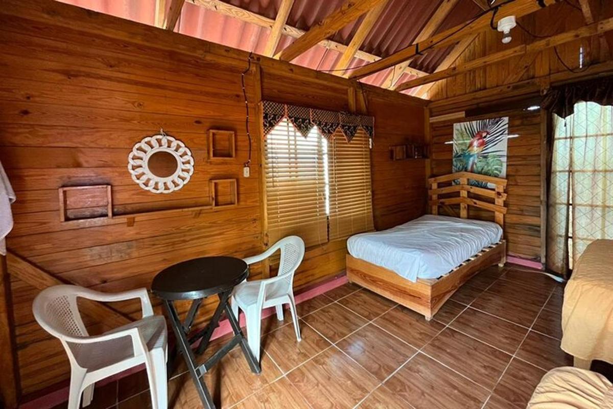 una habitació amb un llit, una taula i cadires