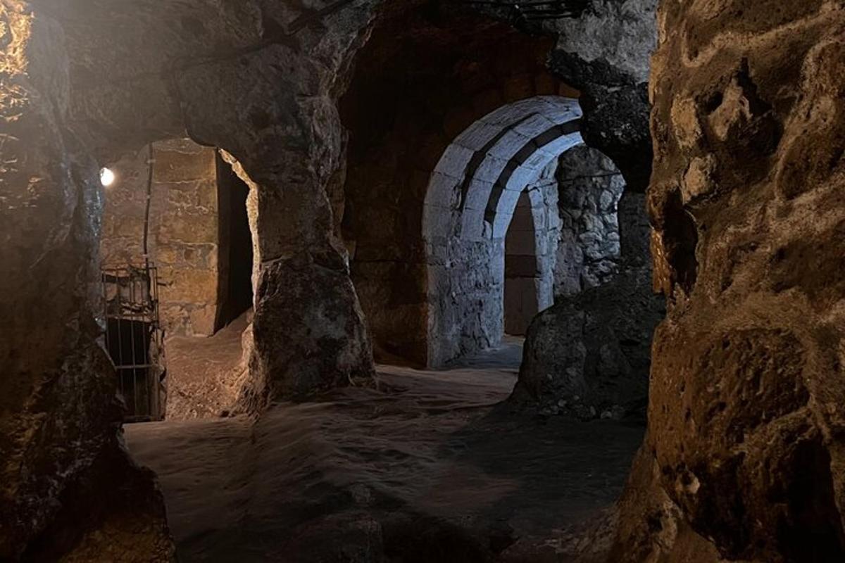 una grotta con un tunnel di pietra con un muro di pietra
