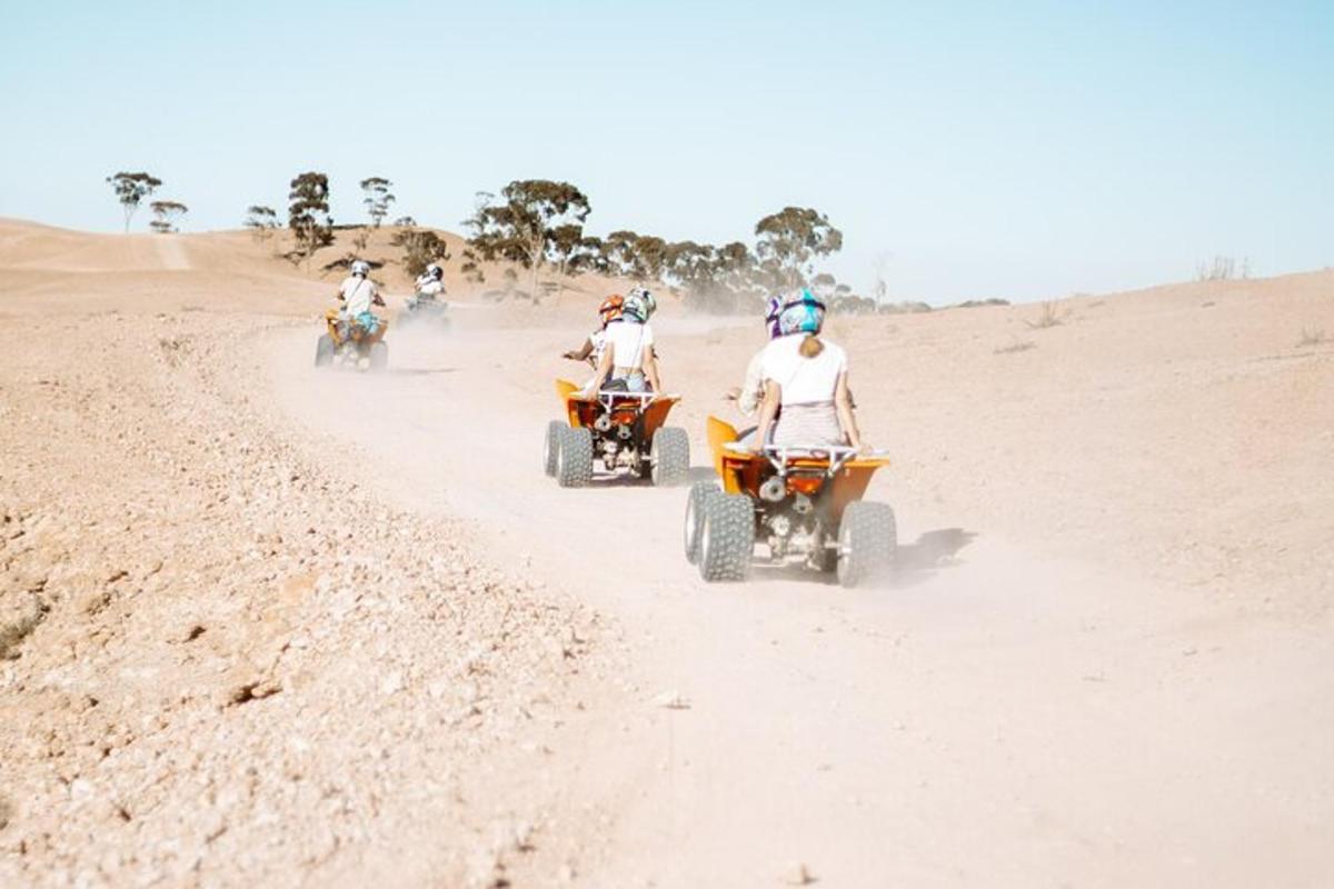 a group of people riding atvs in the desert