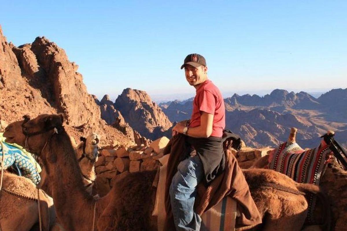 Un hombre monta un camello en el desierto.