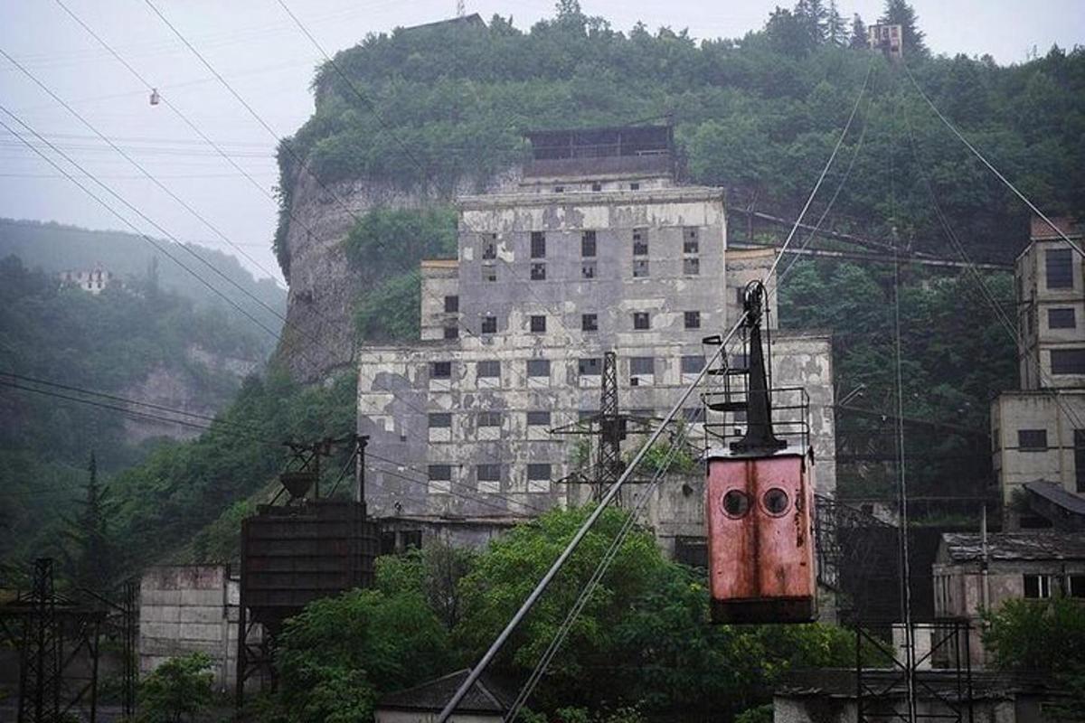 un edificio su una collina con un treno di fronte