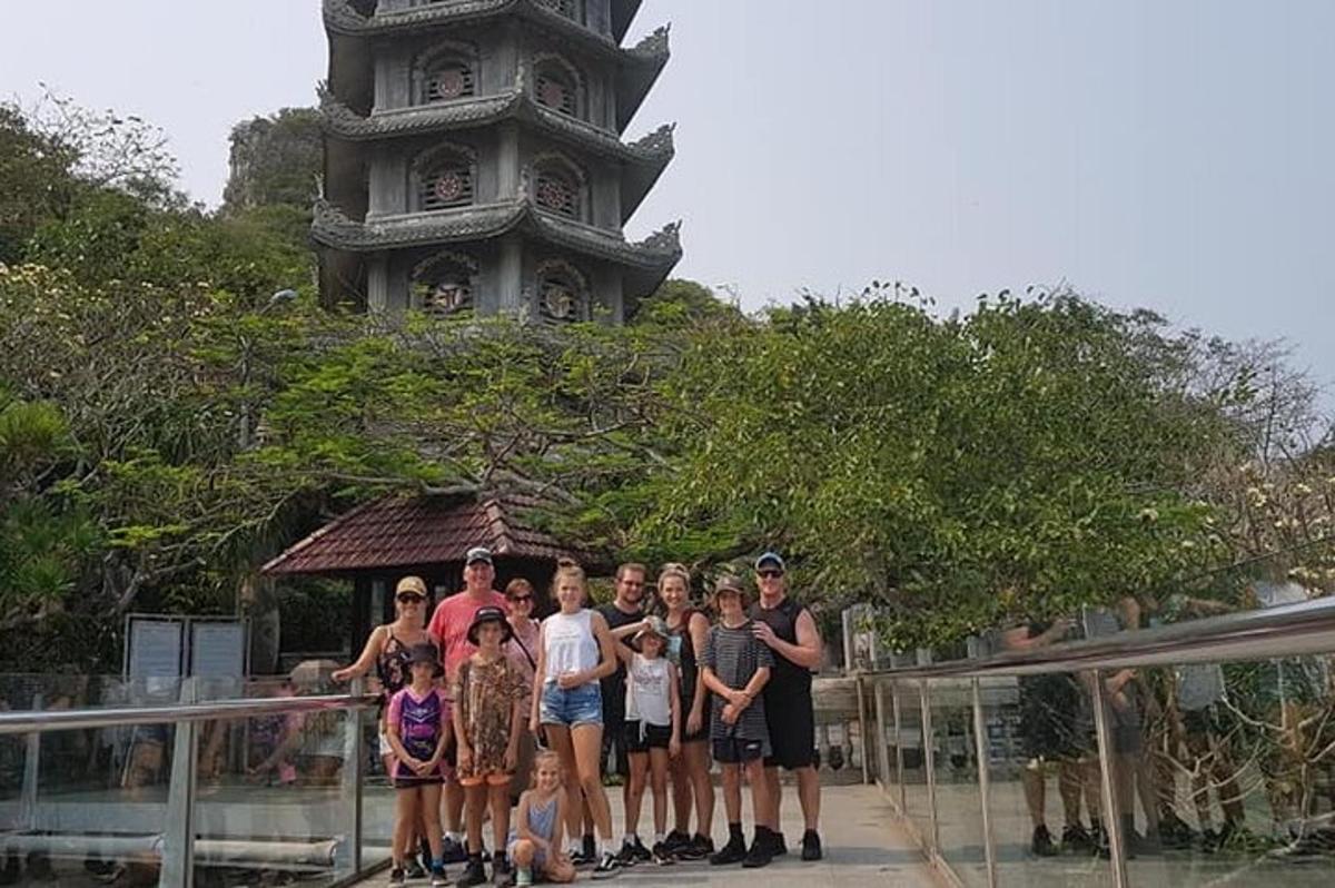 um grupo de pessoas em pé em frente a uma torre