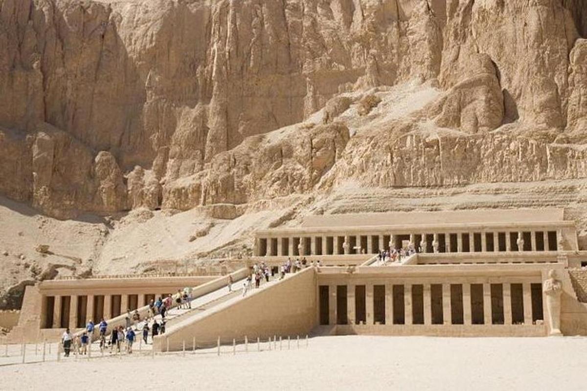 un gruppo di persone che camminano intorno a un edificio in un canyon
