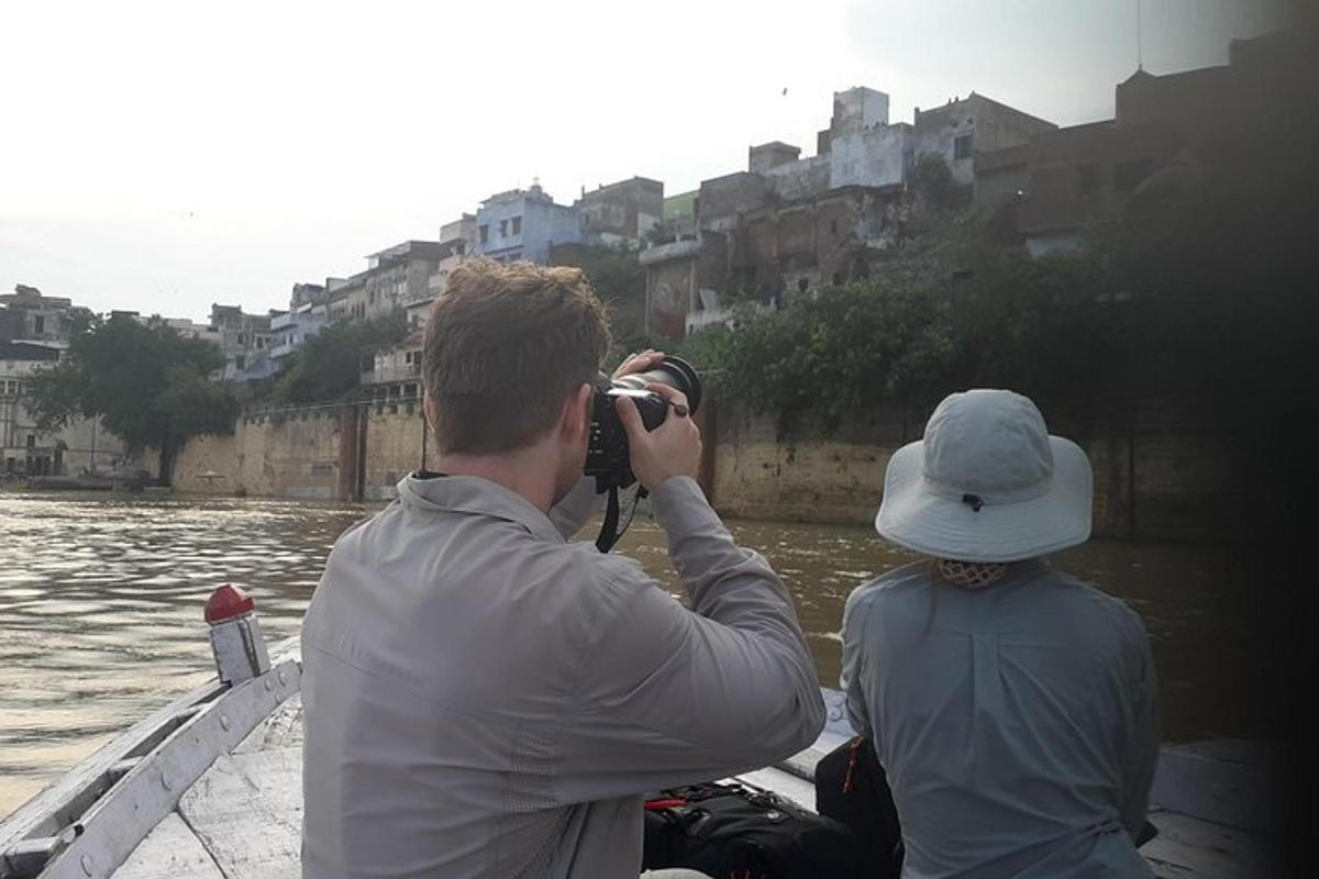 Un hombre tomando una fotografía de una persona en un barco.