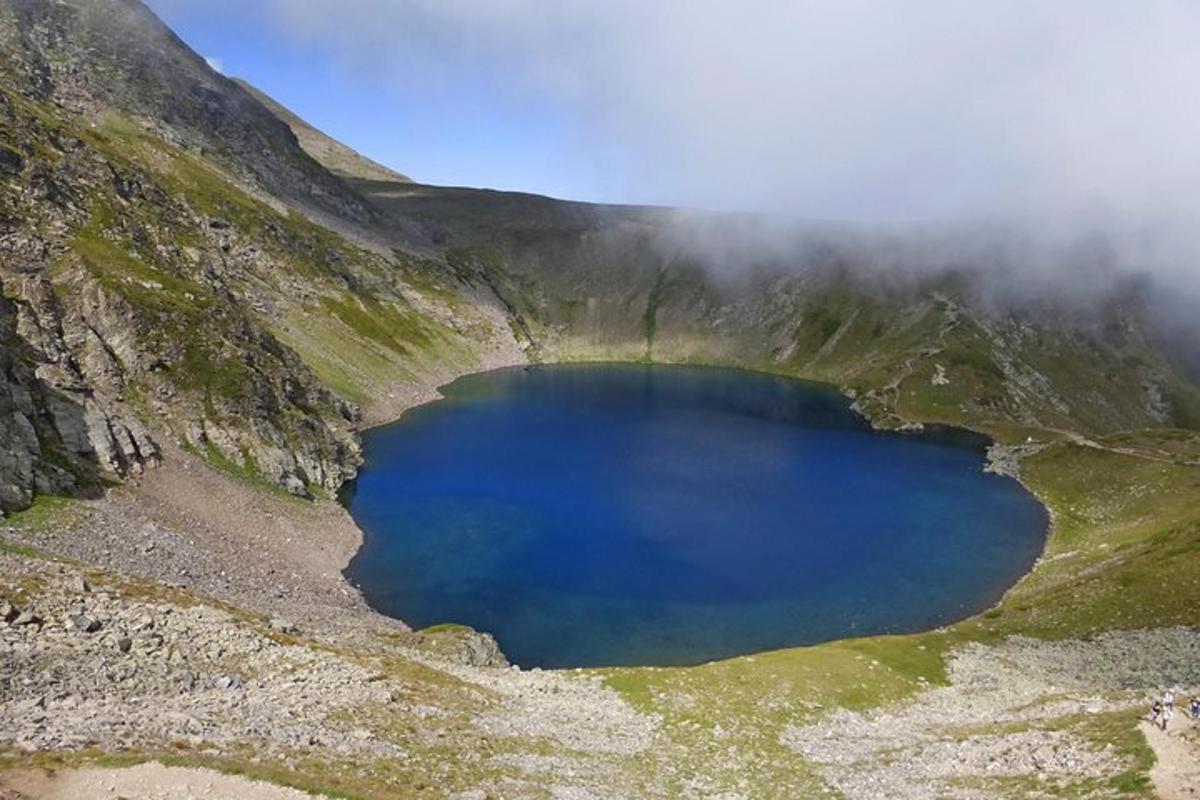 a blue lake in the middle of a mountain