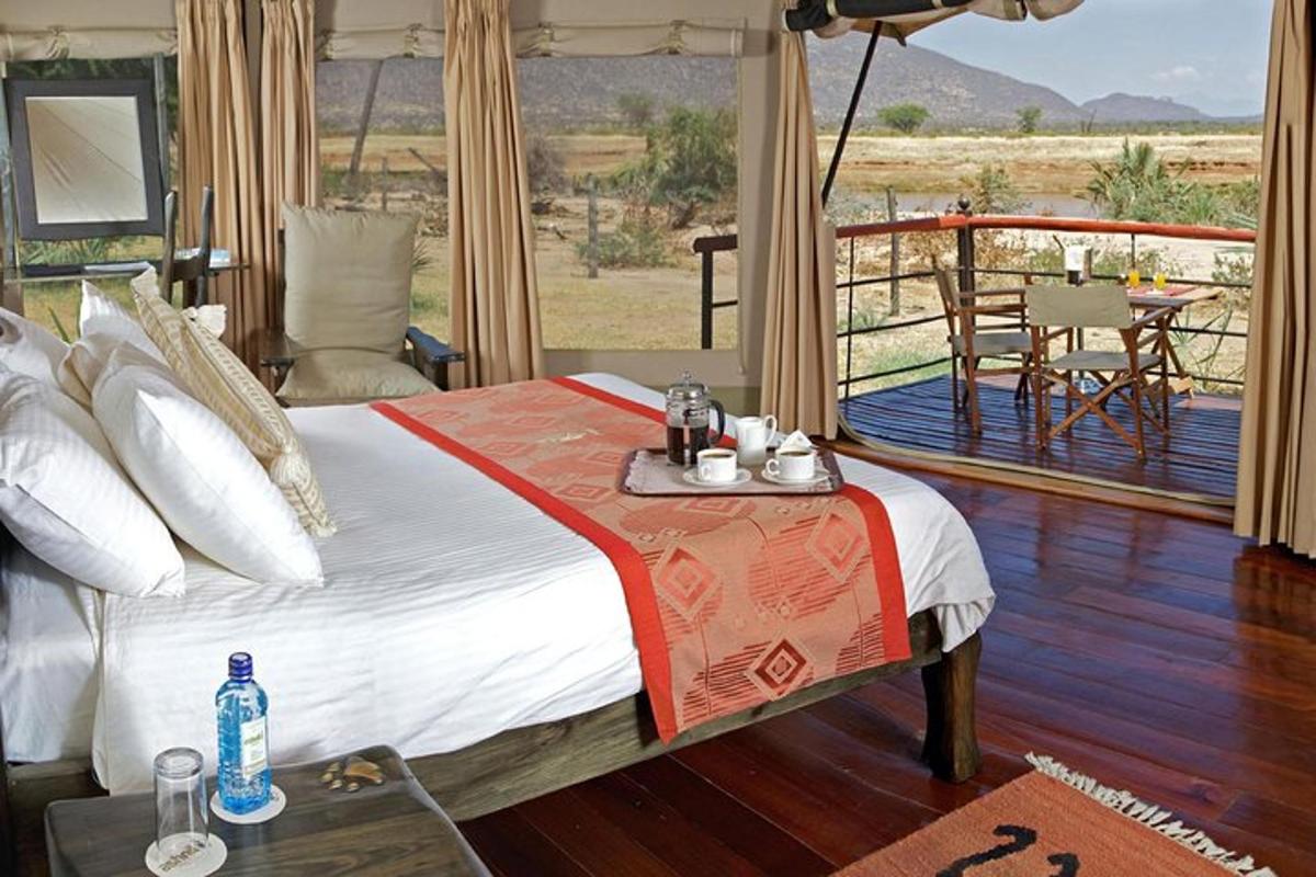 a bedroom with a bed and a balcony with a table