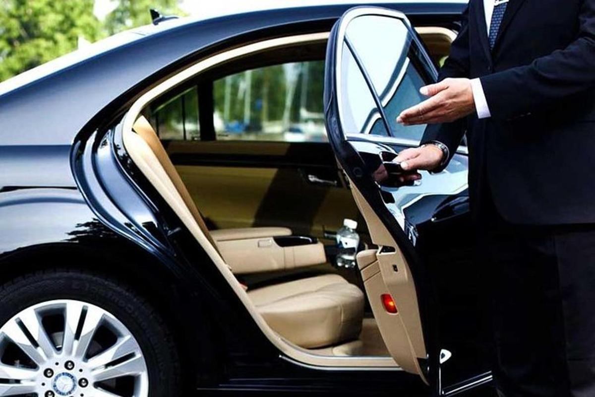 Un hombre con traje subiéndose a un coche.