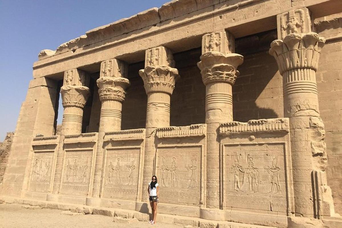 a woman standing in front of a building with columns