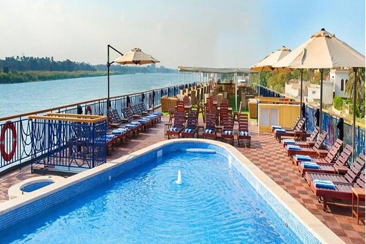 μια πισίνα με καρέκλες και ομπρέλες δίπλα στο νερό