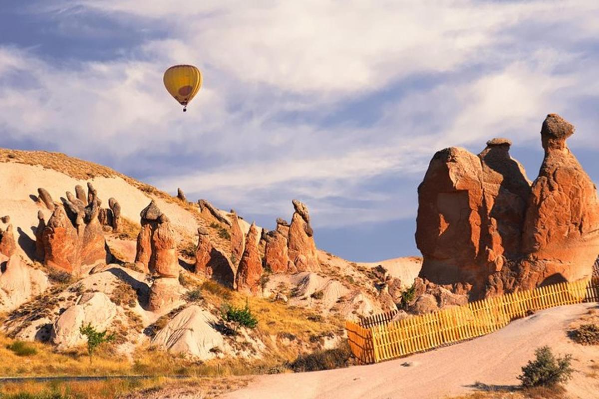 un balon cu aer cald care zboară peste un munte