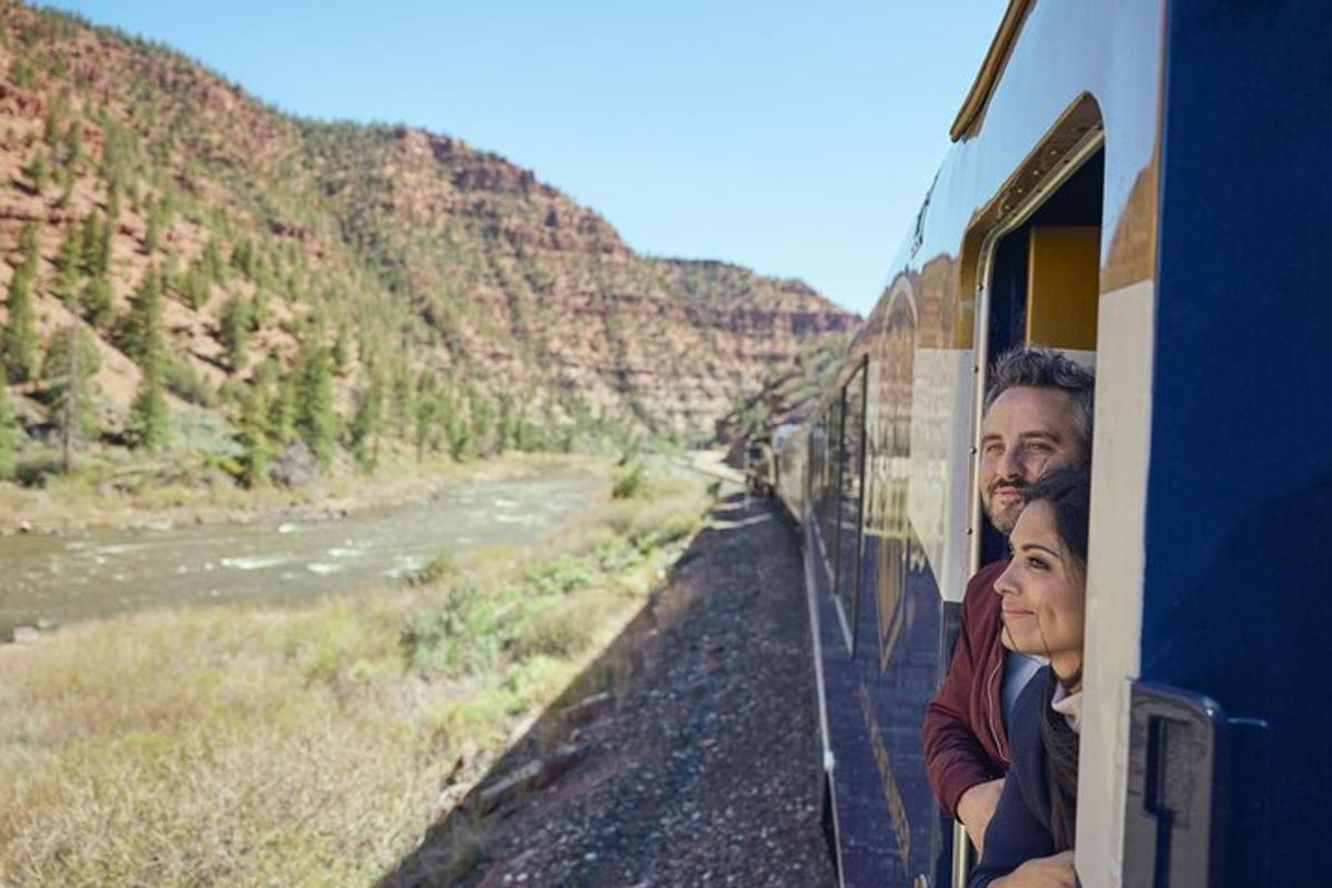Un hombre y una mujer mirando por la ventana de un tren.