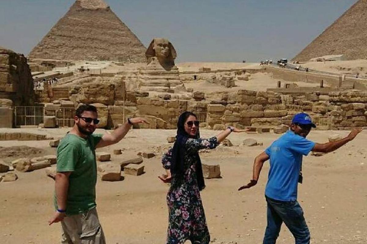 skupina lidí stojící před pyramidami