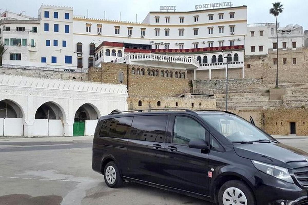 sebuah van hitam diletakkan di tempat letak kereta di hadapan sebuah bangunan